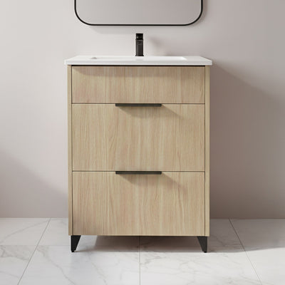 Wooden bathroom vanity with white countertop and black faucet against a plain wall.