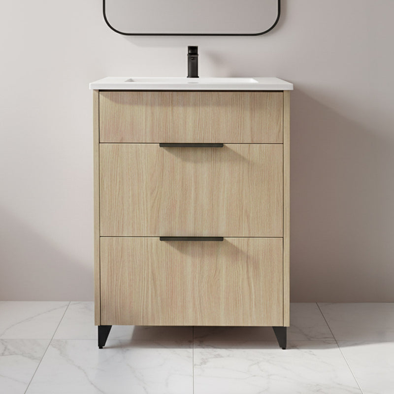 Wooden bathroom vanity with white countertop and black faucet against a plain wall.