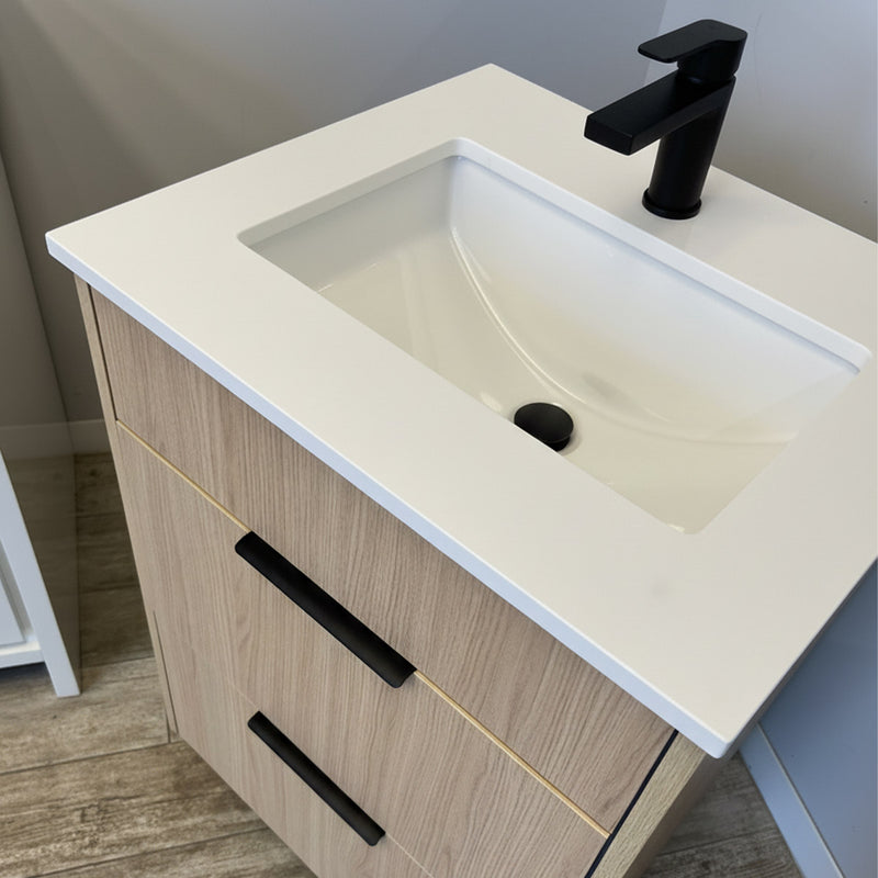 Bathroom vanity with white countertop, sink, and black faucet.