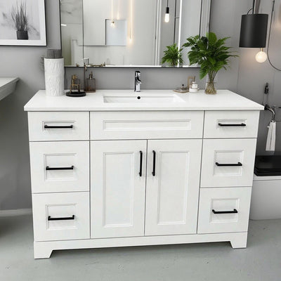 White bathroom vanity with black handles in a modern bathroom setting.