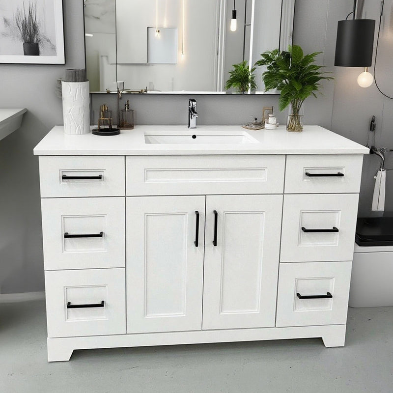 White bathroom vanity with black handles in a modern bathroom setting.