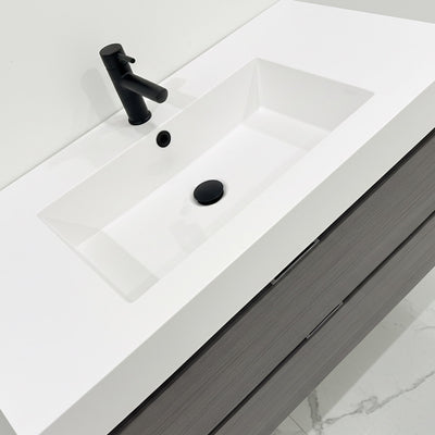 White sink with black faucet on a white countertop