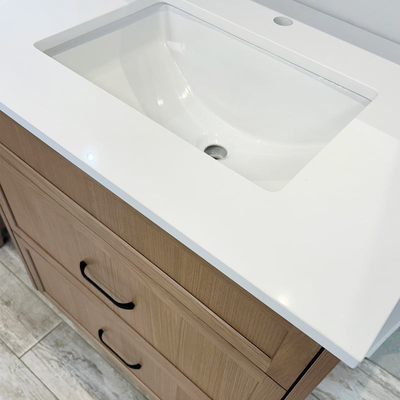 Bathroom vanity with a white undermount sink and wooden cabinets.